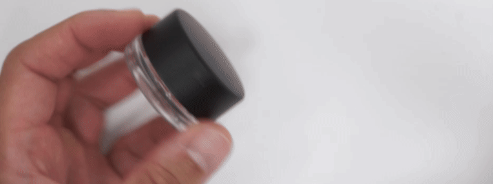 Push-down-and-turn child-resistant concentrate jar closure showing the opening mechanism